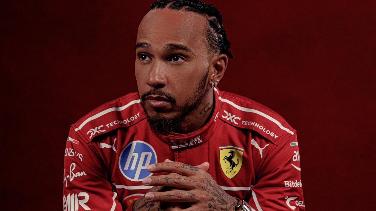 Lewis Hamilton sits in Ferrari F1 racesuit